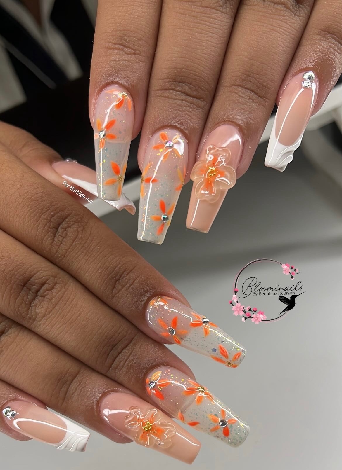 Pose capsule avec fleurs orange et french blanche en gel réalisée à La Réunion chez Bloominails Art